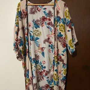 Natural ruana wrap with vibrant flower colors and a black trim